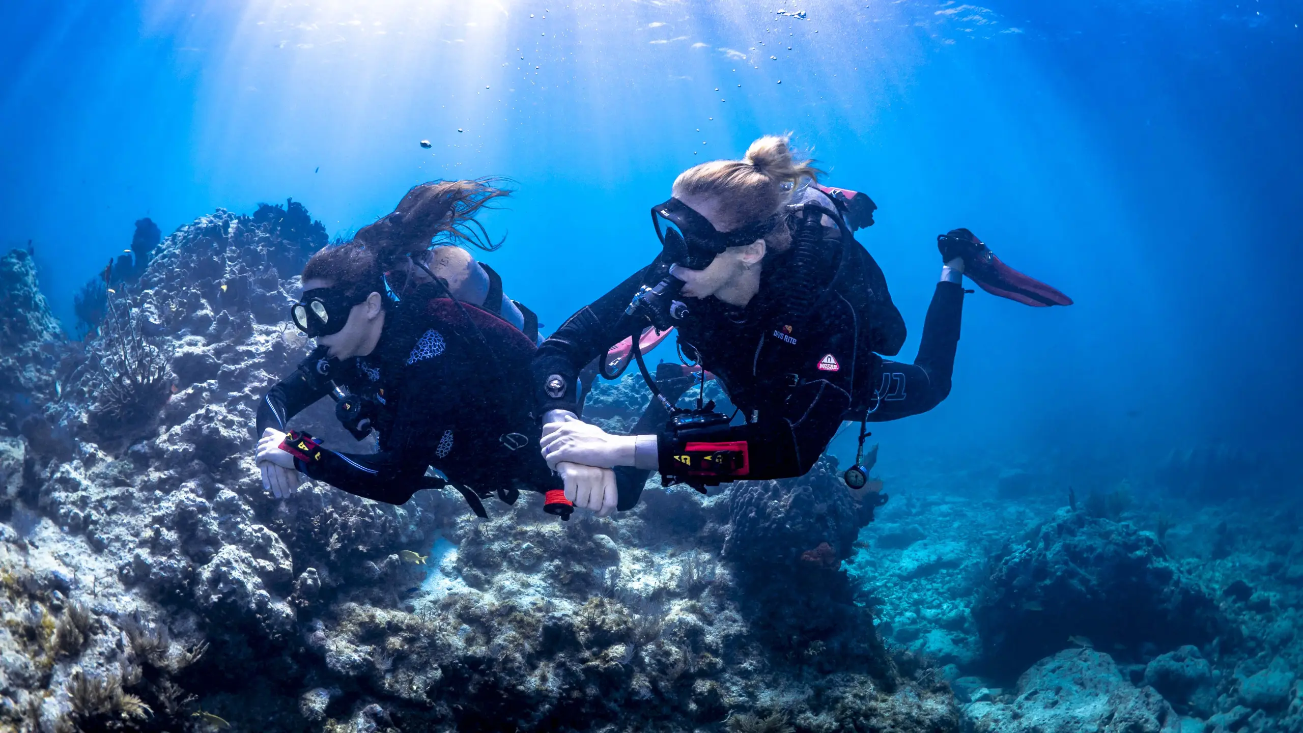 2 duikers langs een rif die leren duiken tijdens de scuba diving international open water cursus.
